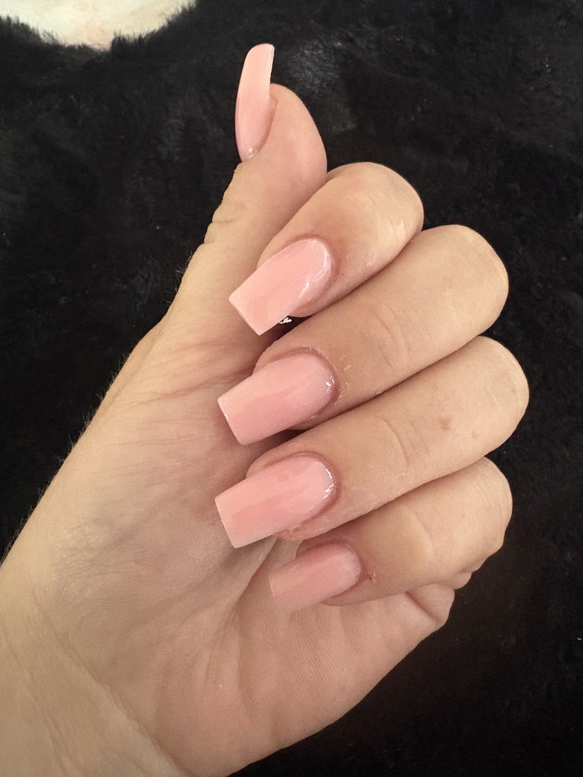 Lange vierkante nagels in zacht roze tegen zwart nepbont